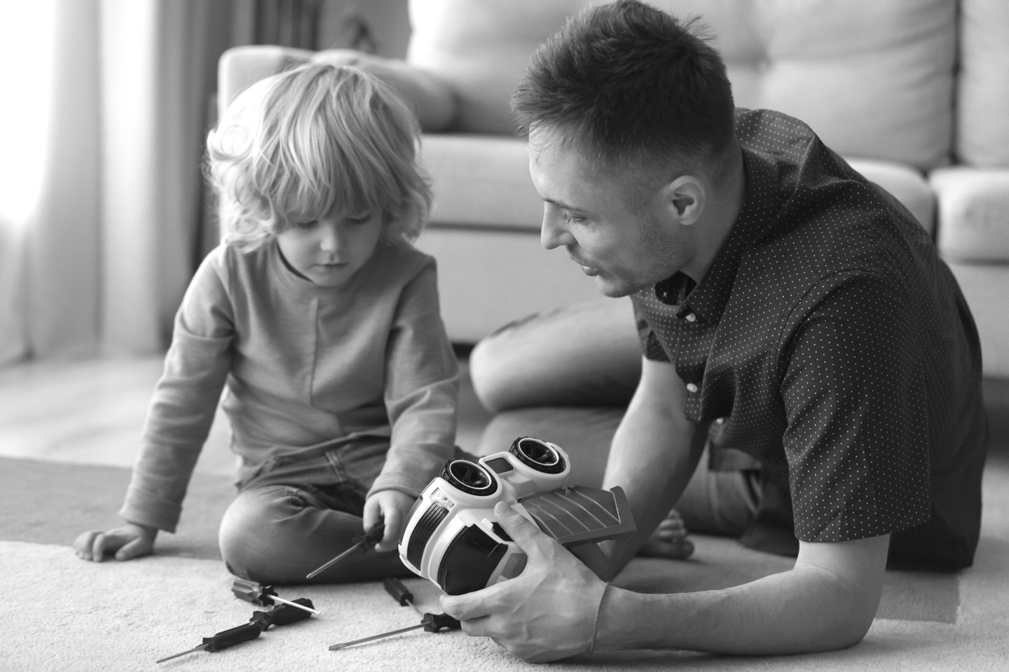 A father and son playing with a toy truck